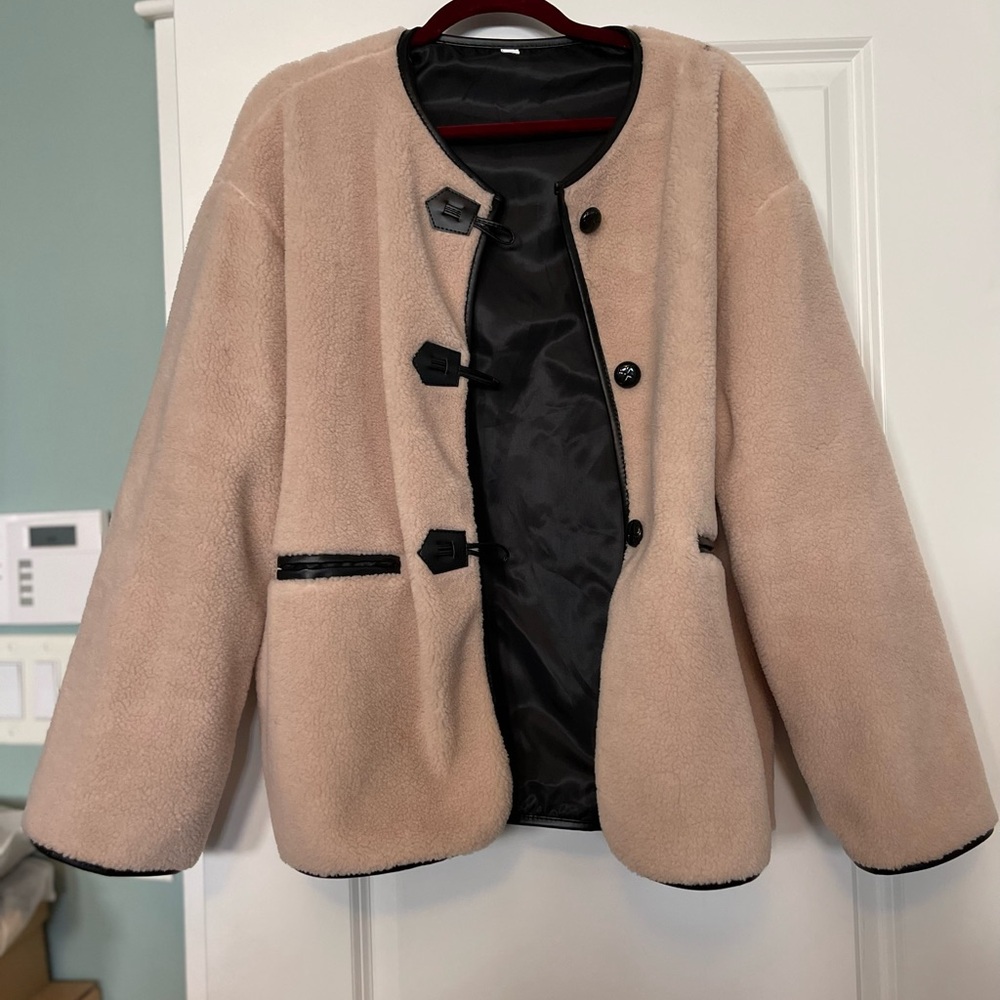 Super comfortable fleece jacket. Cream colored with black buttons.